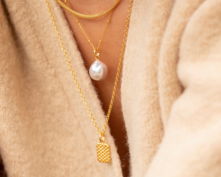 Stacked gold necklace chains with nura pearl pendant