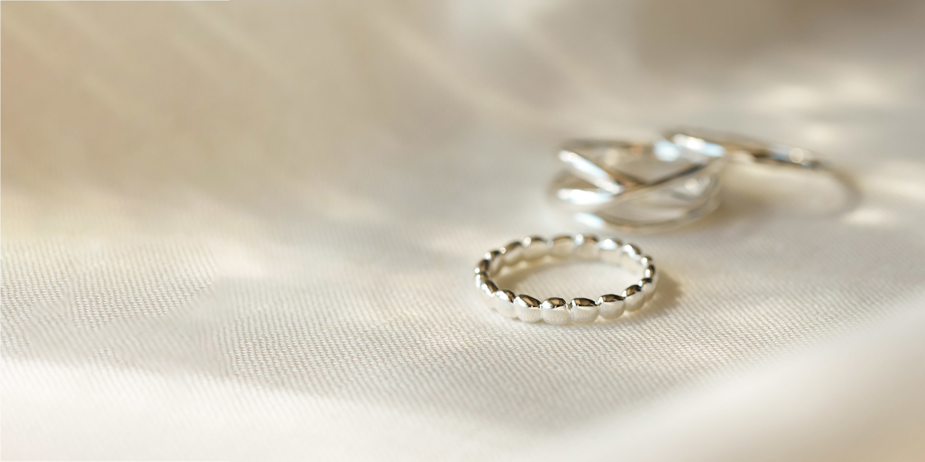 Plain silver rings on white cloth backdrop